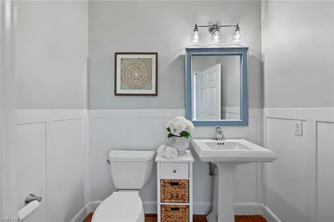 a bathroom with a sink mirror and toilet