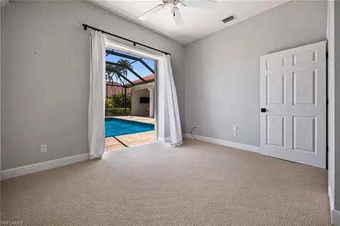 an empty room with a fireplace and a chandelier fan