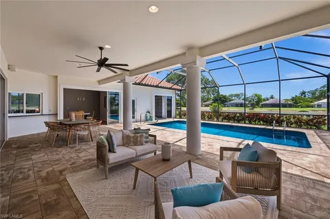 a living room with furniture a flat screen tv and a floor to ceiling window