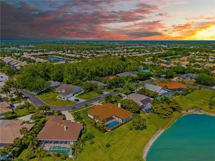 an aerial view of residential houses with outdoor space and trees