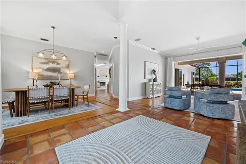a living room with furniture a dining table and a floor to ceiling window