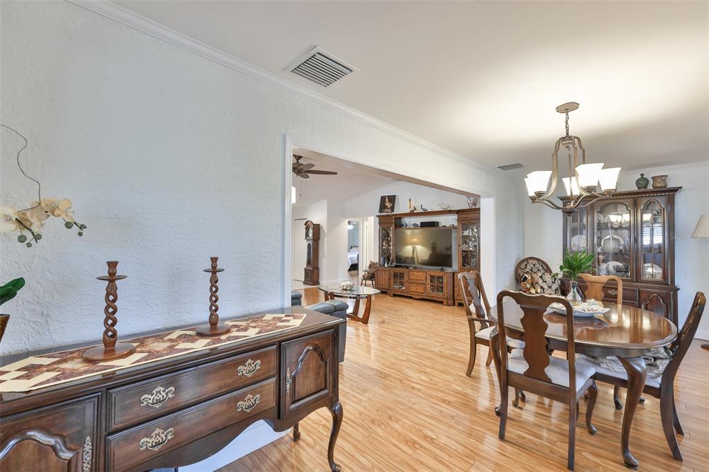 705 Baltusrol Way Sun City Center, FL 33573 - Photo 19 of 59 a view of a dining room with furniture and wooden floor