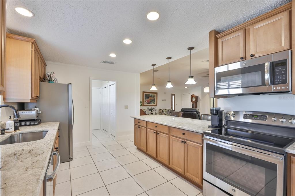 705 Baltusrol Way Sun City Center, FL 33573 - Photo 25 of 59 a kitchen with a sink stove and refrigerator