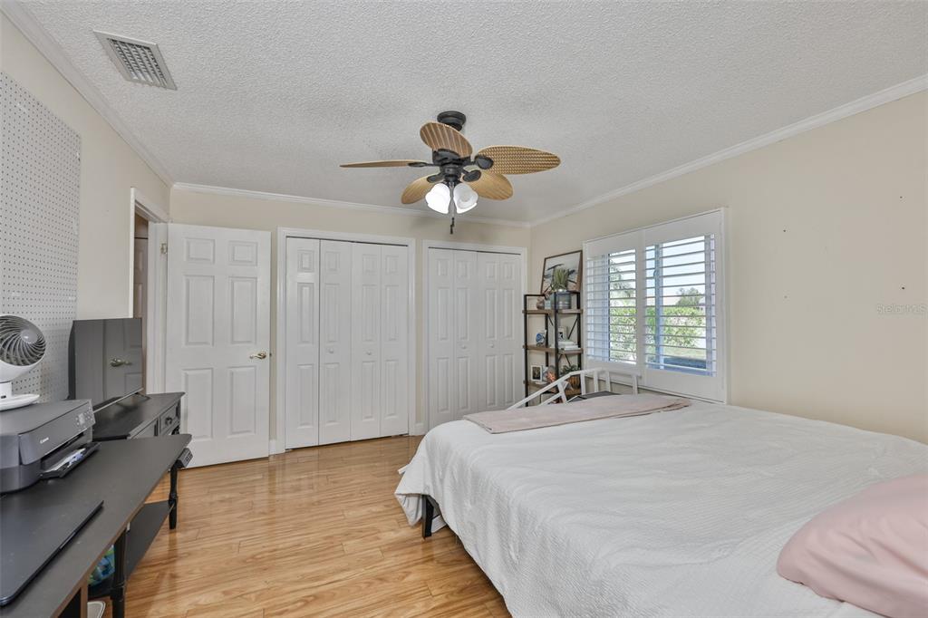 705 Baltusrol Way Sun City Center, FL 33573 - Photo 35 of 59 a bedroom with a bed and a chandelier