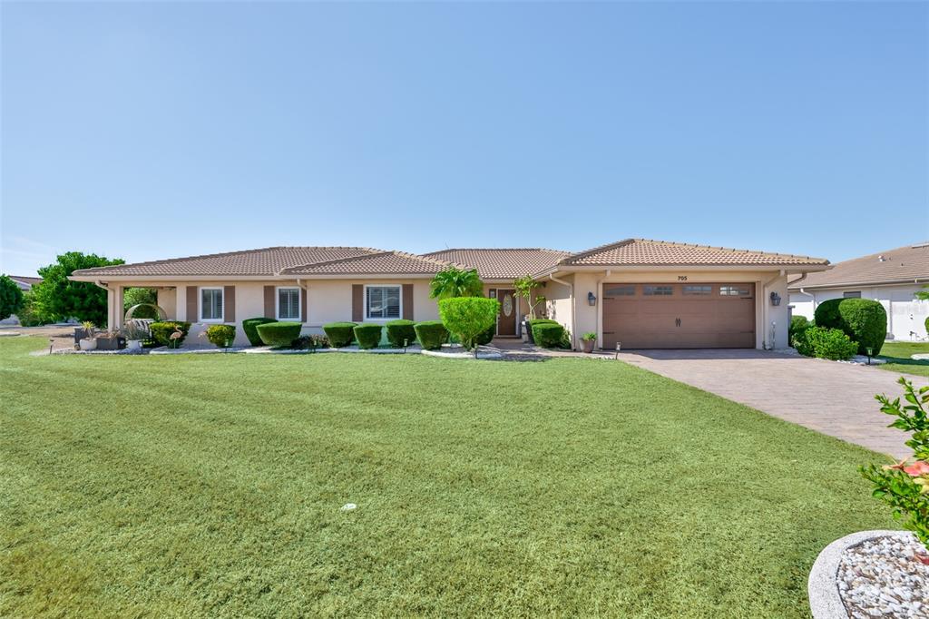 705 Baltusrol Way Sun City Center, FL 33573 - Photo 6 of 59 a front view of a house with a yard and trees