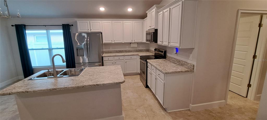 13052 Ogden Glade Road Dade City, FL 33525 - Photo 21 of 35 a kitchen with stainless steel appliances granite countertop a refrigerator and a sink