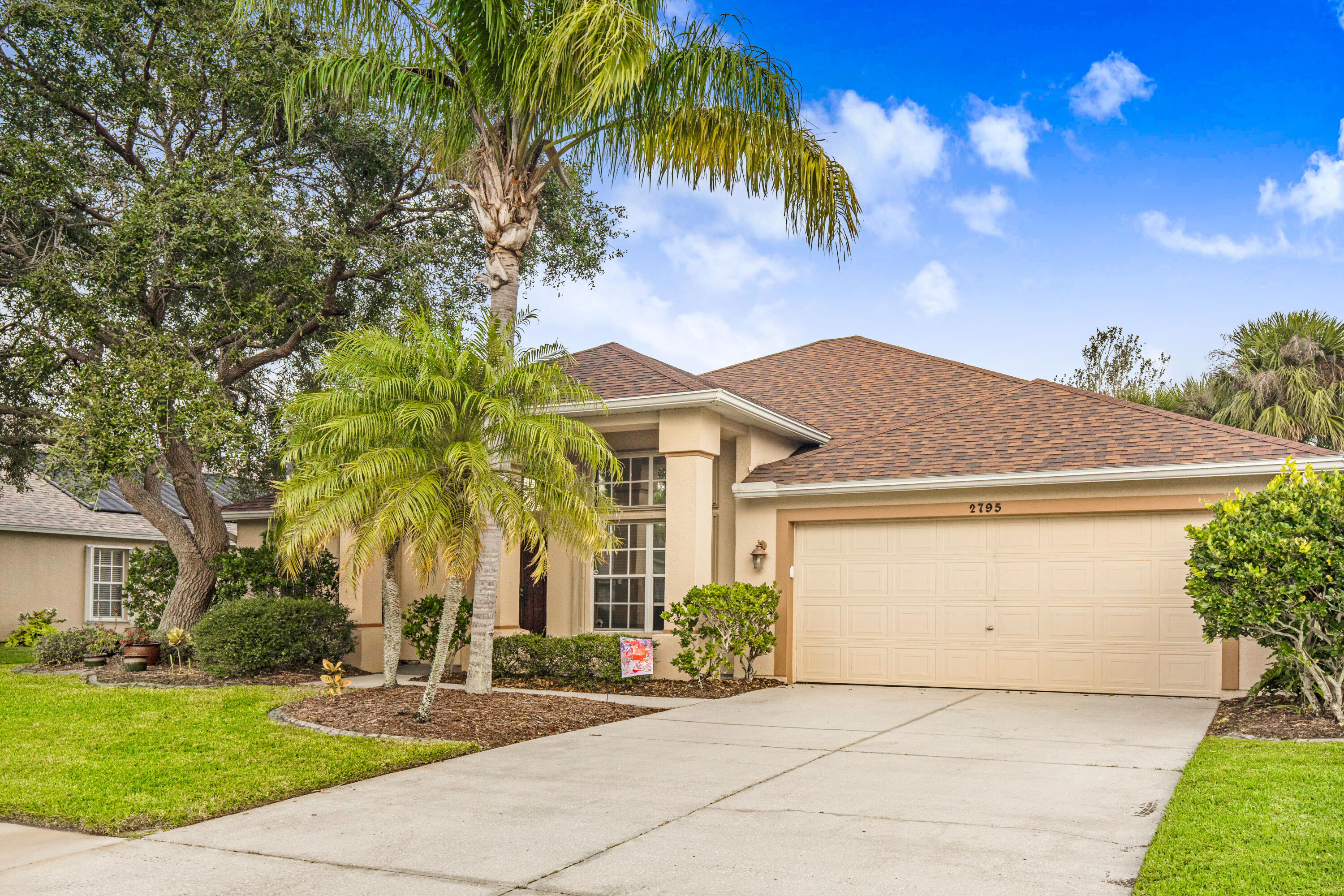 2795 Whistler Street Melbourne, FL 32904 - Photo 44 of 45 a front view of a house with a garden and palm trees