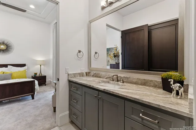 a bathroom with a granite countertop sink a mirror a toilet and shower