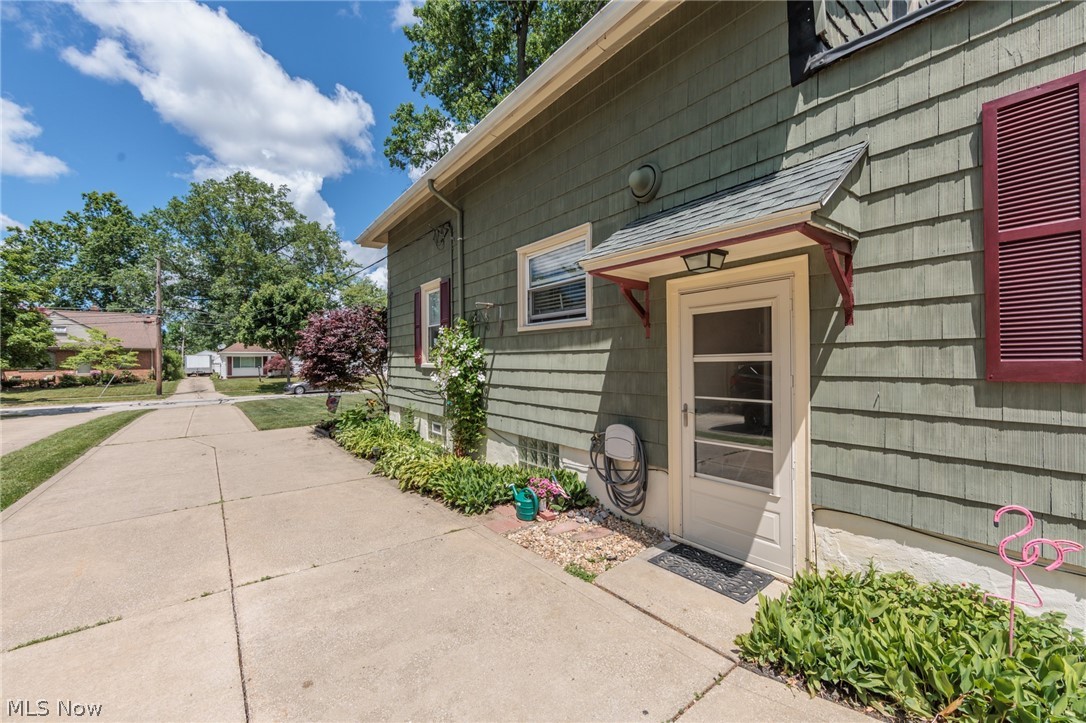 5364 Summit Road Lyndhurst, OH 44124 - Photo 2 of 42 Side entry with a storm door under a shingled awning, green shingle siding, and red louvered shutters