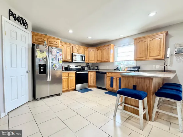 a kitchen with stainless steel appliances granite countertop a stove top oven a sink a dining table and chairs