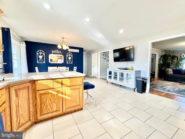 a view of living room kitchen with stainless steel appliances granite countertop cabinets and flat screen tv