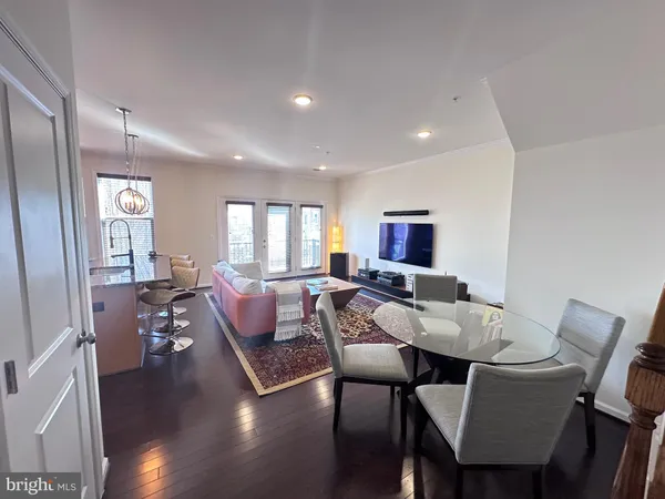 a living room with furniture a wooden floor and a flat screen tv