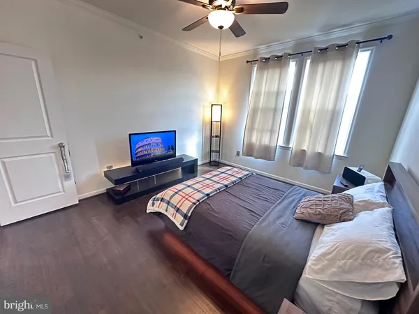 a bedroom with a bed a dresser and a chandelier