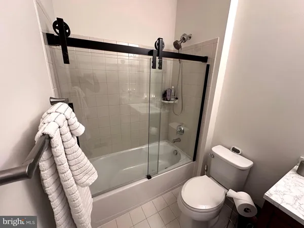 a bathroom with a sink a toilet a mirror and shower