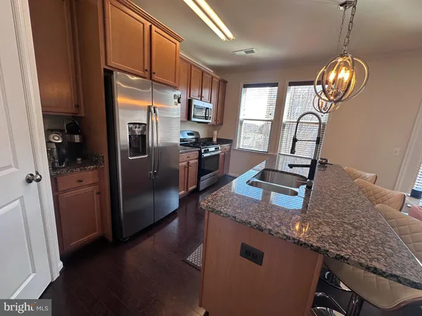 a kitchen with stainless steel appliances granite countertop a sink refrigerator and stove