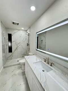 a bathroom with a double vanity sink mirror and toilet
