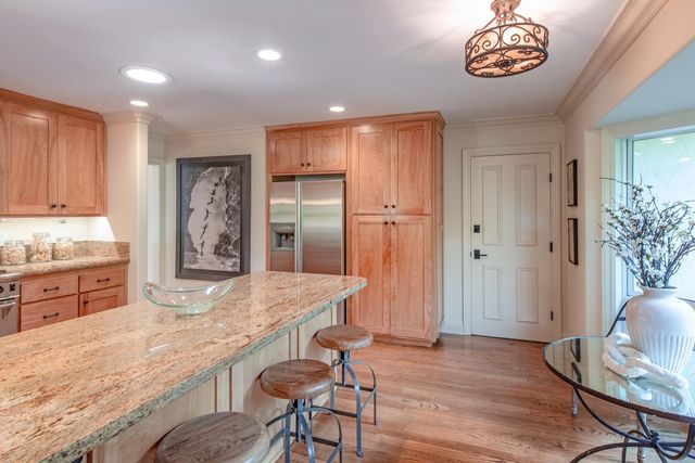 a large kitchen with stainless steel appliances granite countertop a stove and a refrigerator