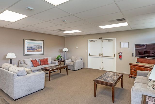 a living room with furniture a flat screen tv and a table