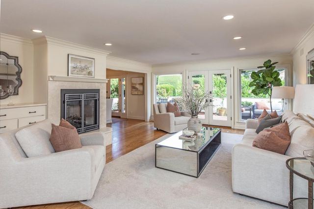 a living room with furniture fireplace and potted plants
