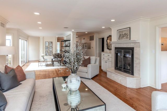 a living room with furniture a fireplace and a chandelier