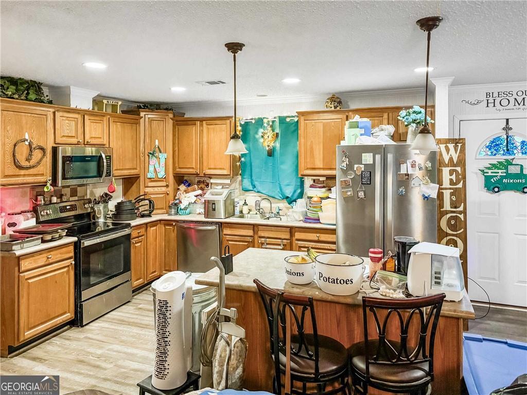 230 Surrett Road Buchanan, GA 30113 - Photo 4 of 17 a kitchen with stainless steel appliances kitchen island granite countertop a table chairs and a refrigerator