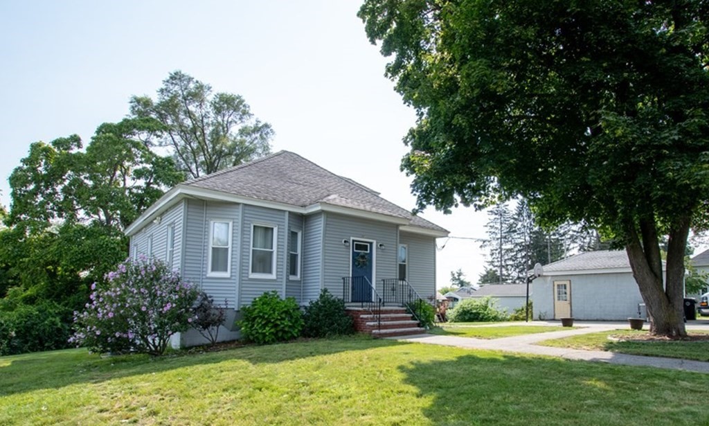 a front view of a house with a yard and trees