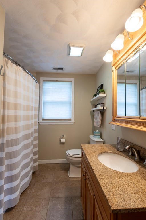 97 Bay State Road Methuen, MA 01844 - Photo 12 of 26 a bathroom with a granite countertop sink a mirror and a toilet