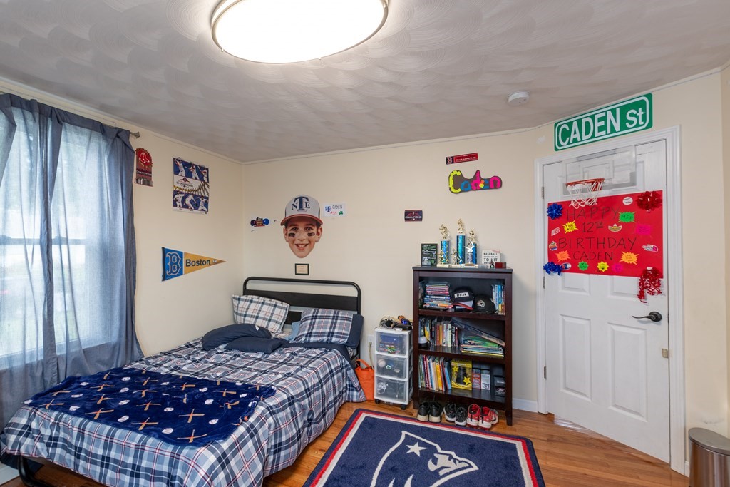 97 Bay State Road Methuen, MA 01844 - Photo 17 of 26 a bedroom with a bed and wooden floor