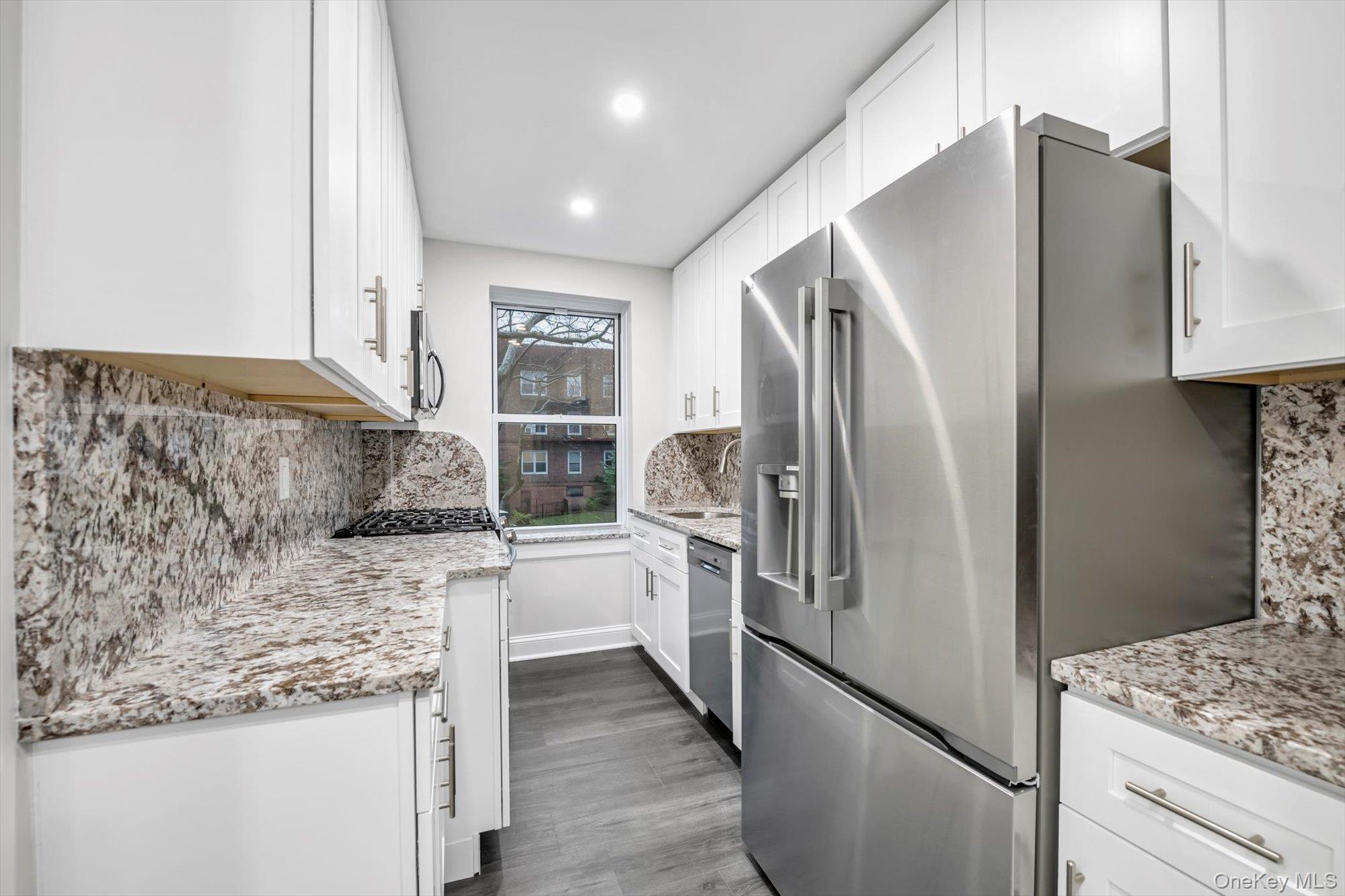 79-06 Main Street, Unit 2J Queens, NY 11367 - Photo 2 of 12 a kitchen with stainless steel appliances granite countertop a refrigerator and a stove