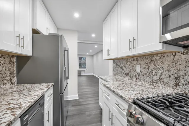 a kitchen with granite countertop a stove and a refrigerator