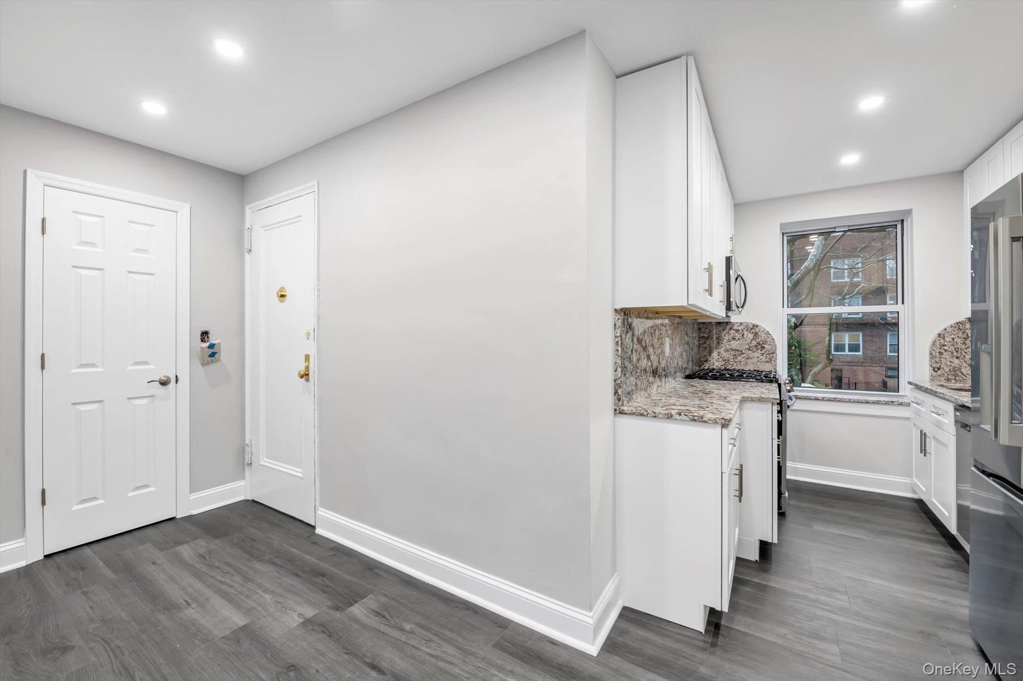 79-06 Main Street, Unit 2J Queens, NY 11367 - Photo 4 of 12 a kitchen with a refrigerator and white cabinets