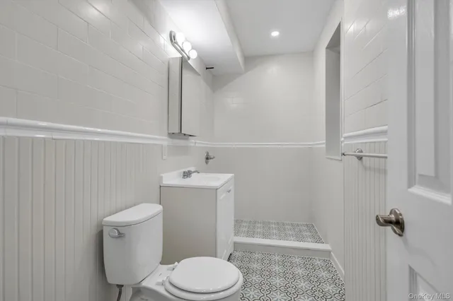 a bathroom with a toilet a sink and mirror