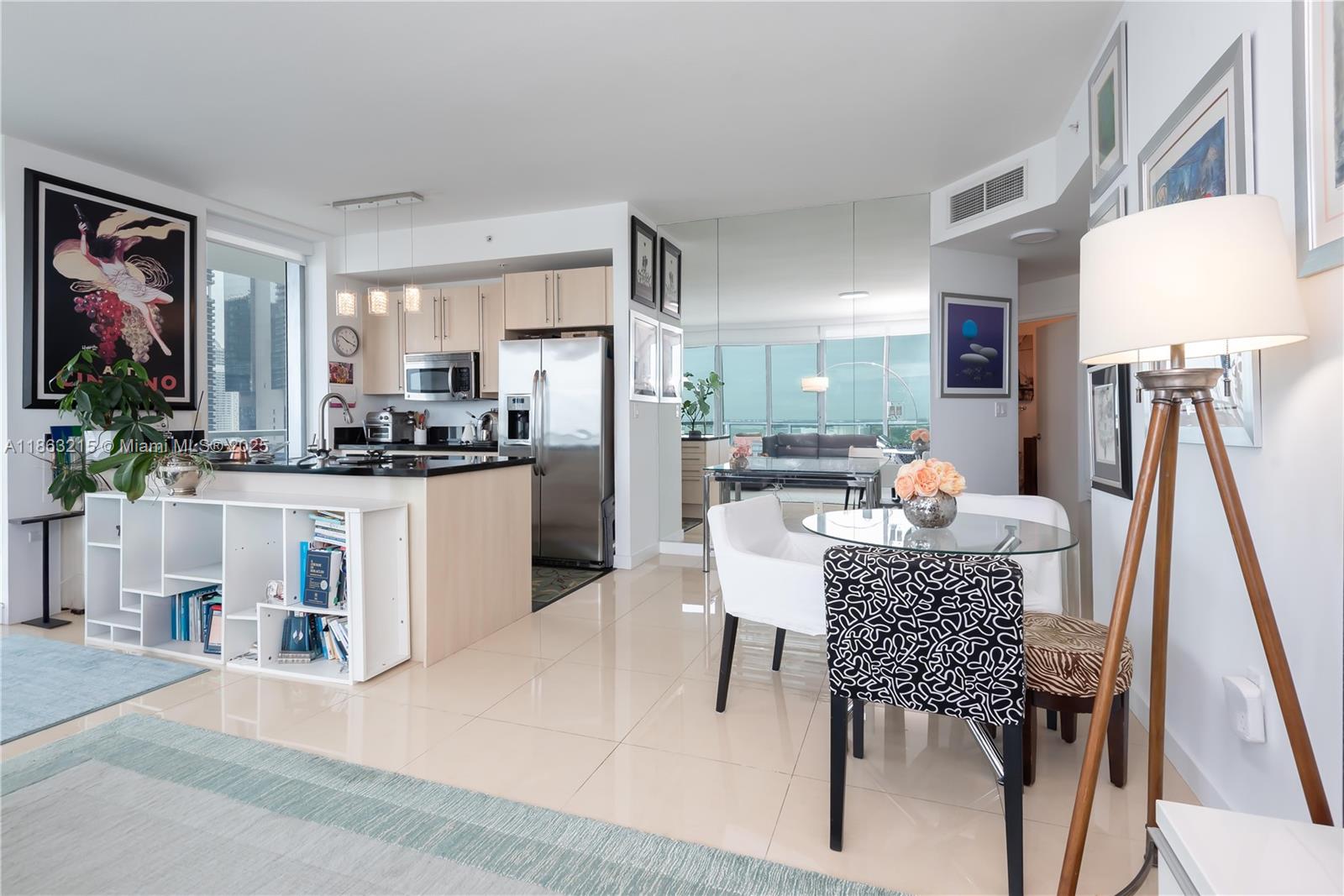 1111 Southwest 1st Avenue, Unit 3125N Miami, FL 33130 - Photo 7 of 49 a kitchen with stainless steel appliances kitchen island granite countertop a refrigerator a stove a microwave oven a dining table and chairs with wooden floor