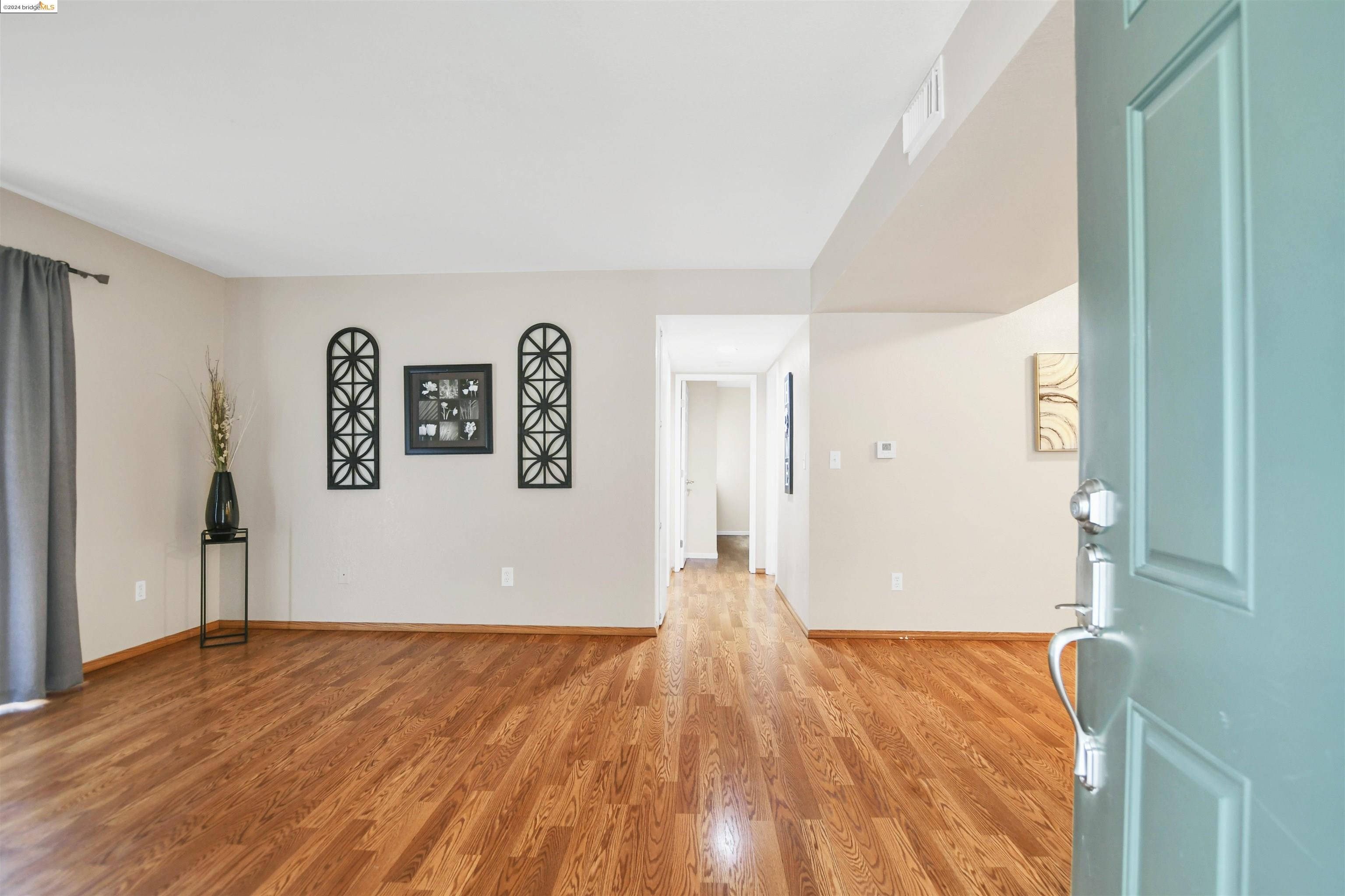 a view of empty room with wooden floor