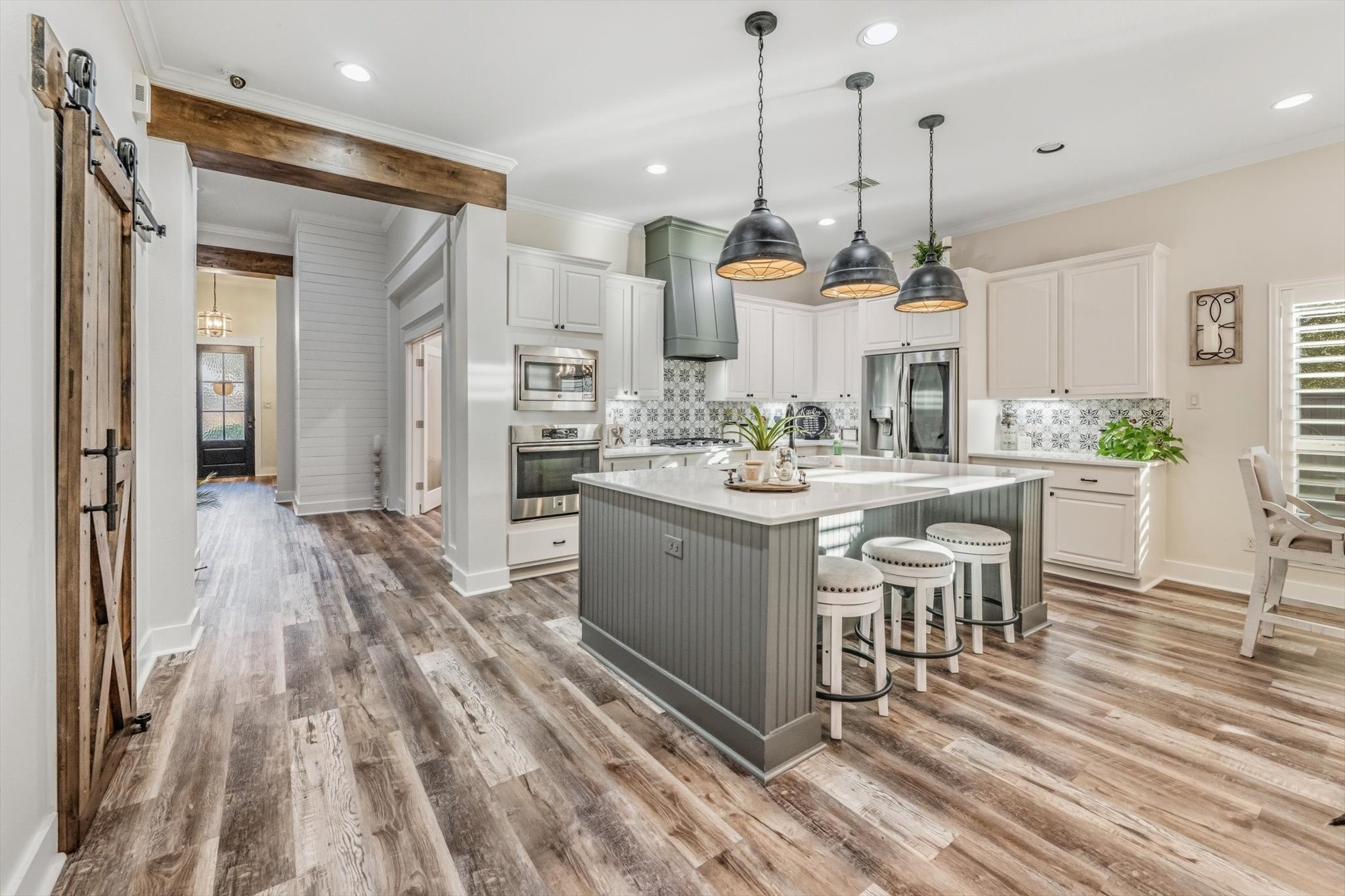 103 Fox Rindle Road Montgomery, TX 77316 - Photo 4 of 44 An entertainer’s dream kitchen featuring an expansive island with seating, custom vent hood, 5 burner cooktop and striking pendant lighting. Seamlessly blending function and sophistication at the heart of the home.