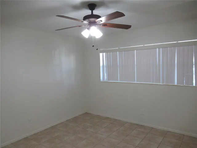 an empty room with a chandelier fan