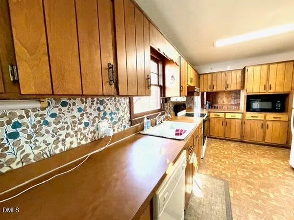a kitchen with a refrigerator a stove top oven and a sink