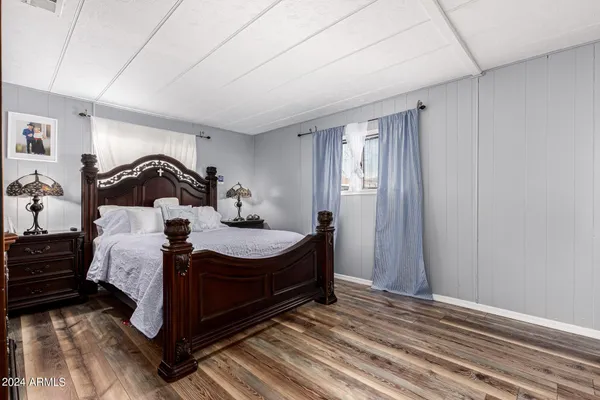 a bedroom with a bed and wooden floor