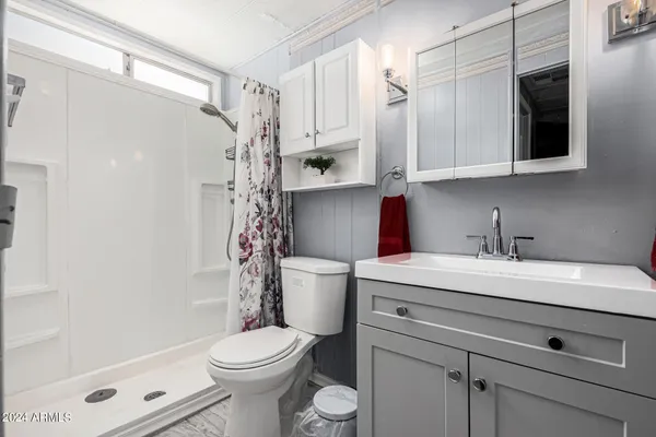 a bedroom with a bed and a flat tv screen on dresser