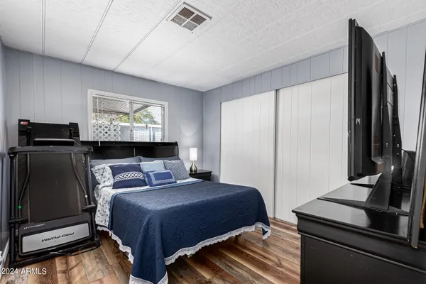 a bedroom with a bed and wooden floor