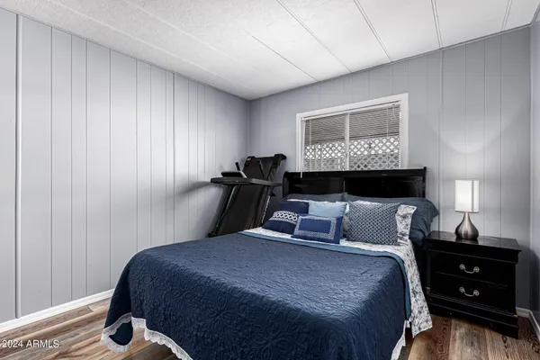 a bedroom with a bed and a flat tv screen on dresser
