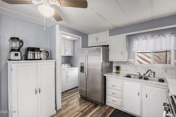 a kitchen with stainless steel appliances a refrigerator a stove a sink dishwasher a microwave oven with cabinets and wooden floor
