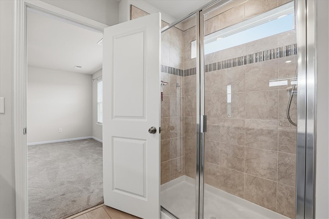 365 Sliding Rock Drive Pendleton, SC 29670 - Photo 28 of 46 Walk-in shower with tile surround and glass enclosure adjoins a plush, carpeted room.