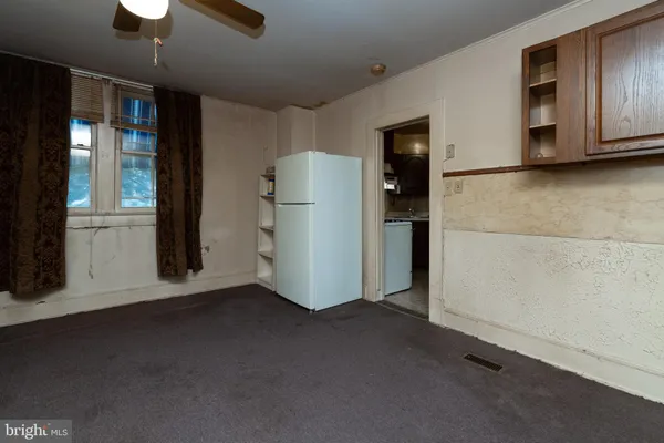 a view of a kitchen with a refrigerator and cabinets