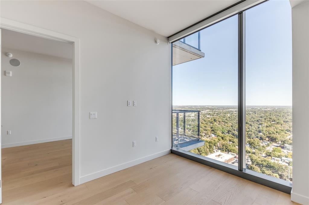 44 East Avenue, Unit 3109 Austin, TX 78701 - Photo 12 of 37 Unfurnished room featuring a wall of windows, baseboards, and light wood finished floors