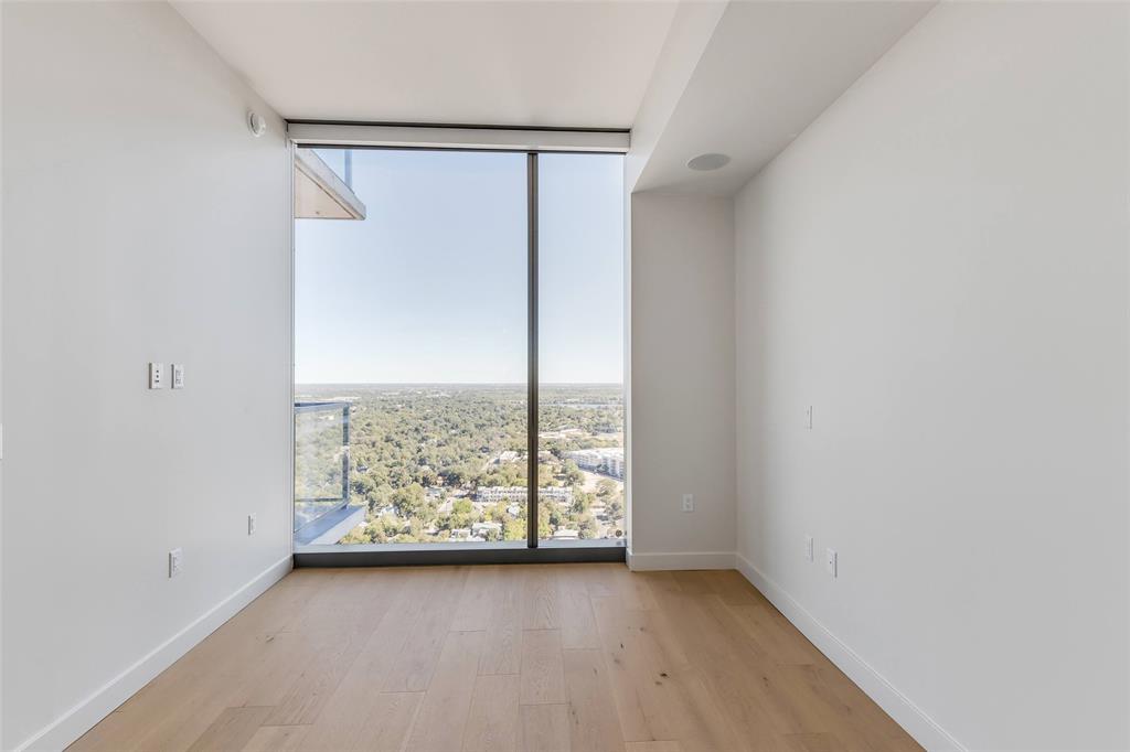 44 East Avenue, Unit 3109 Austin, TX 78701 - Photo 13 of 37 Empty room with floor to ceiling windows, baseboards, and wood finished floors