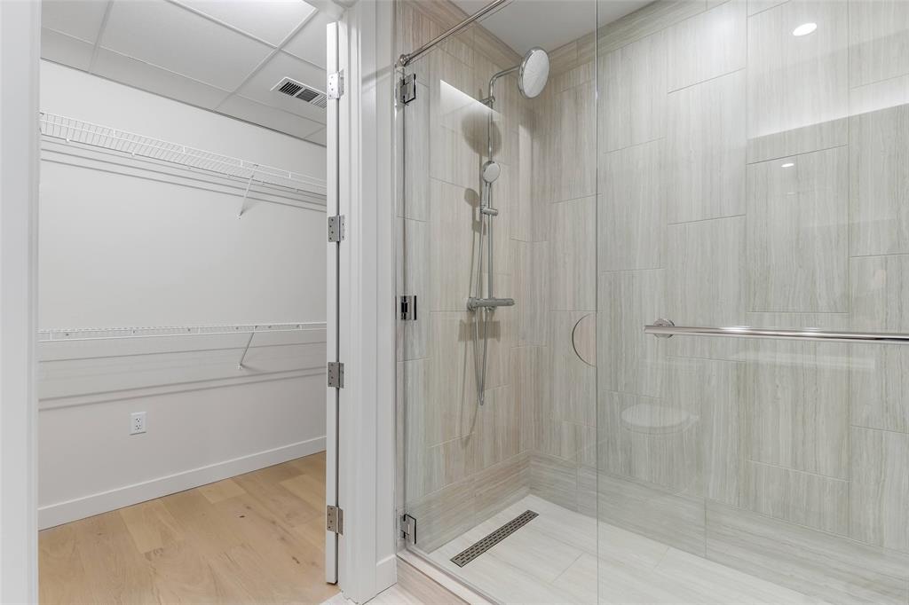 44 East Avenue, Unit 3109 Austin, TX 78701 - Photo 16 of 37 Full bath with visible vents, wood finished floors, a shower stall, baseboards, and a spacious closet