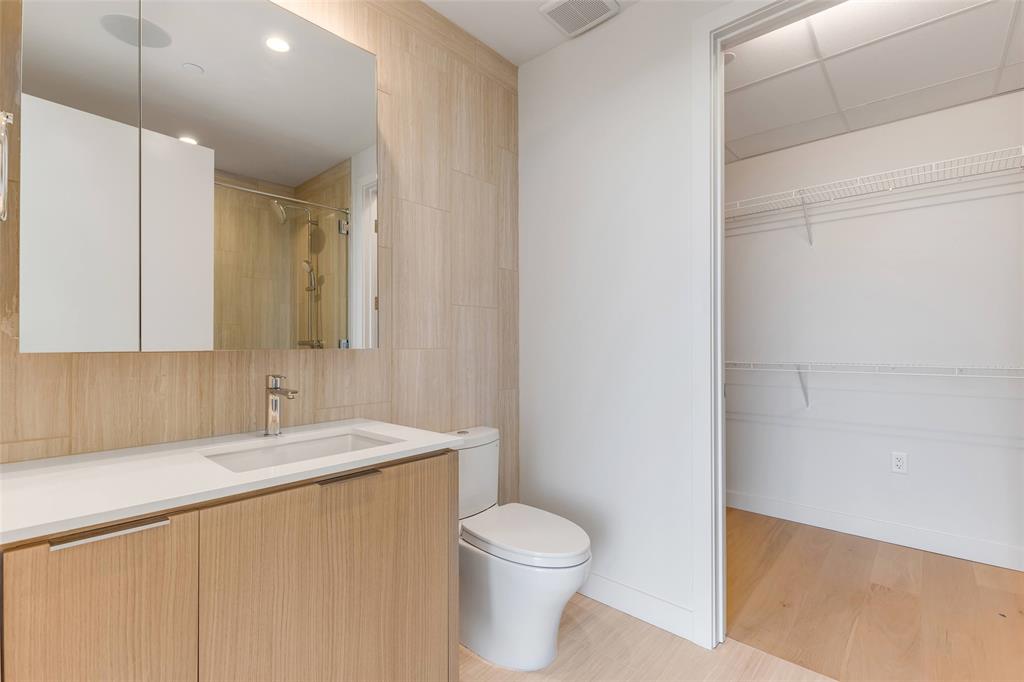 44 East Avenue, Unit 3109 Austin, TX 78701 - Photo 18 of 37 Bathroom with visible vents, walk in shower, toilet, wood finished floors, and vanity