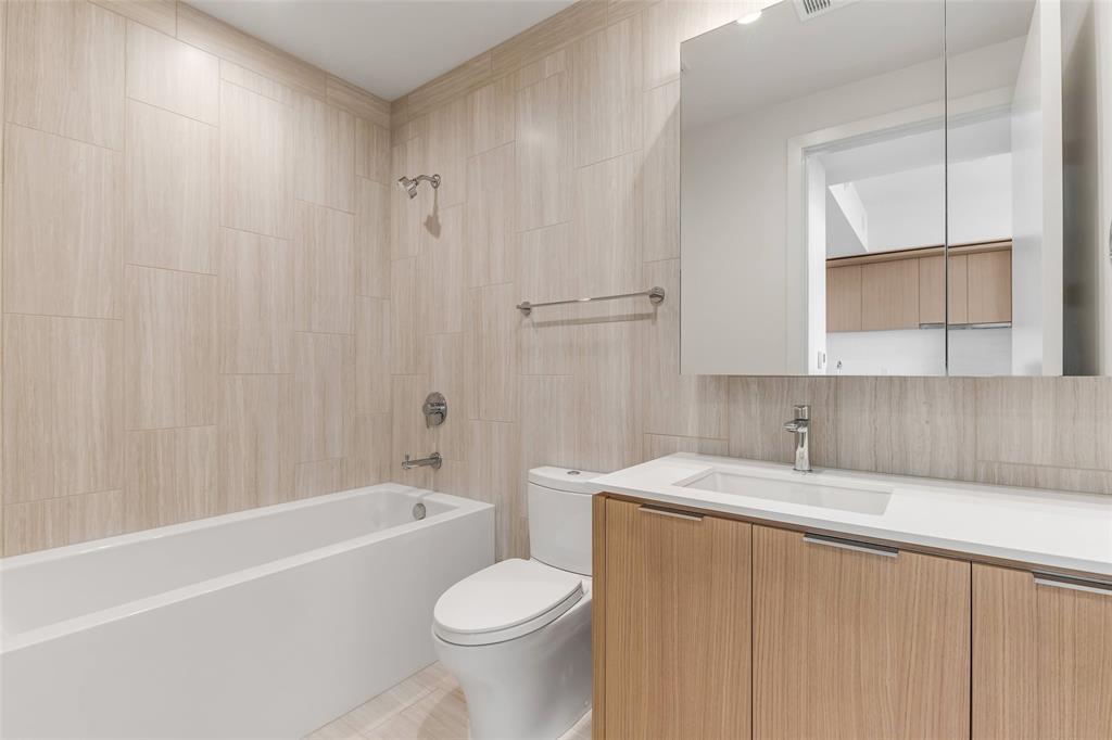 44 East Avenue, Unit 3109 Austin, TX 78701 - Photo 19 of 37 Full bath with tile walls, shower / washtub combination, toilet, decorative backsplash, and vanity