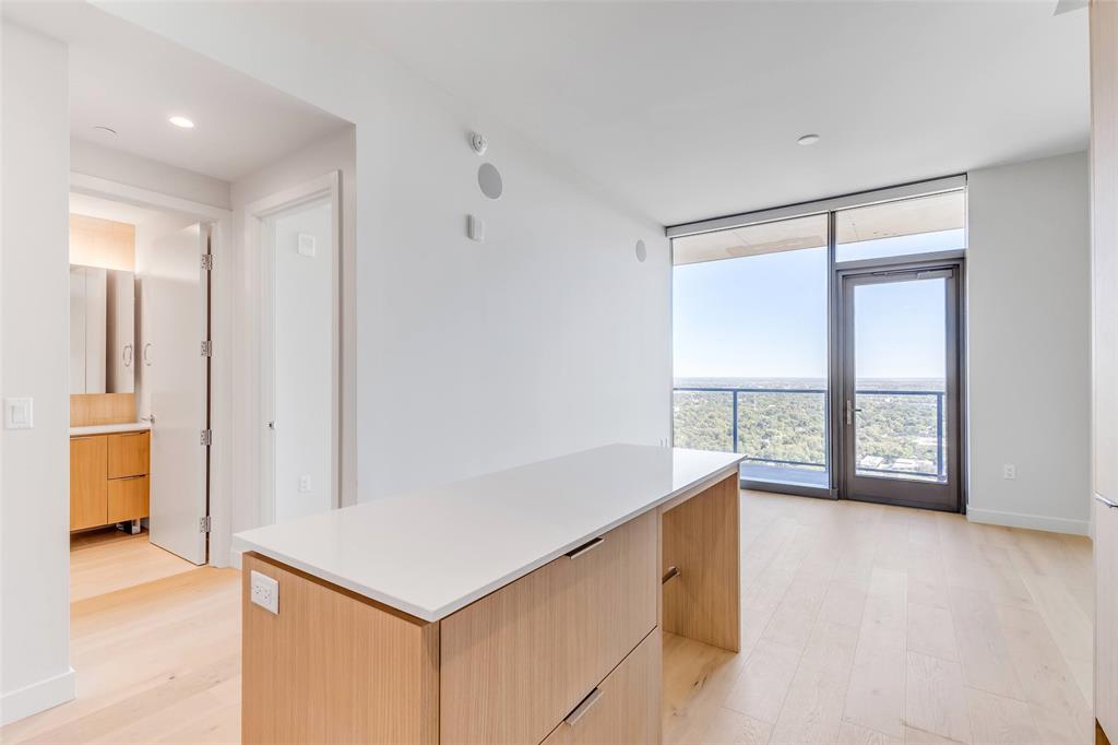 44 East Avenue, Unit 3109 Austin, TX 78701 - Photo 5 of 37 Kitchen with a center island, light brown cabinetry, expansive windows, light wood-style flooring, and modern cabinets